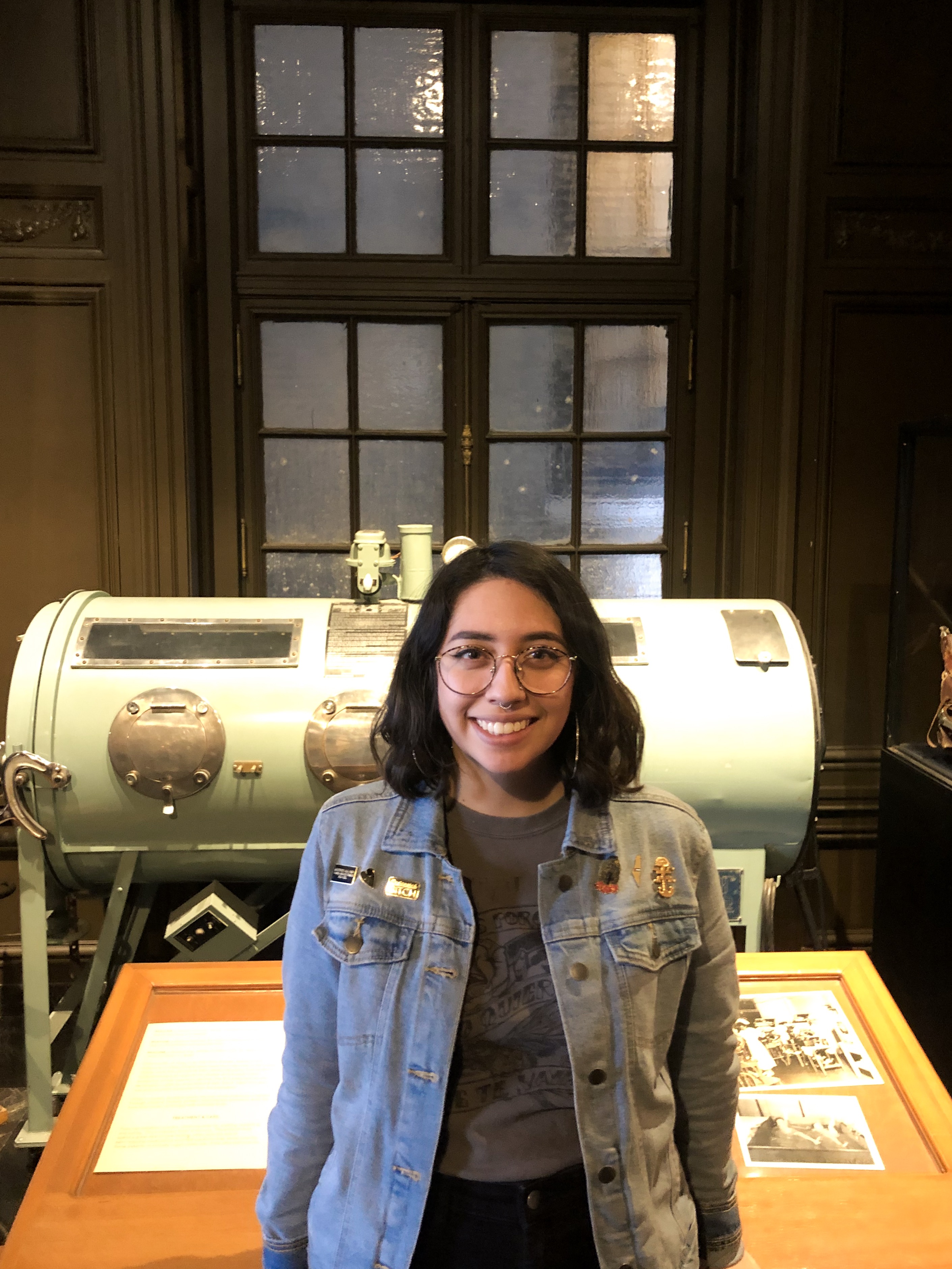 Image of education intern, Jackie, in front of the Iron Lung