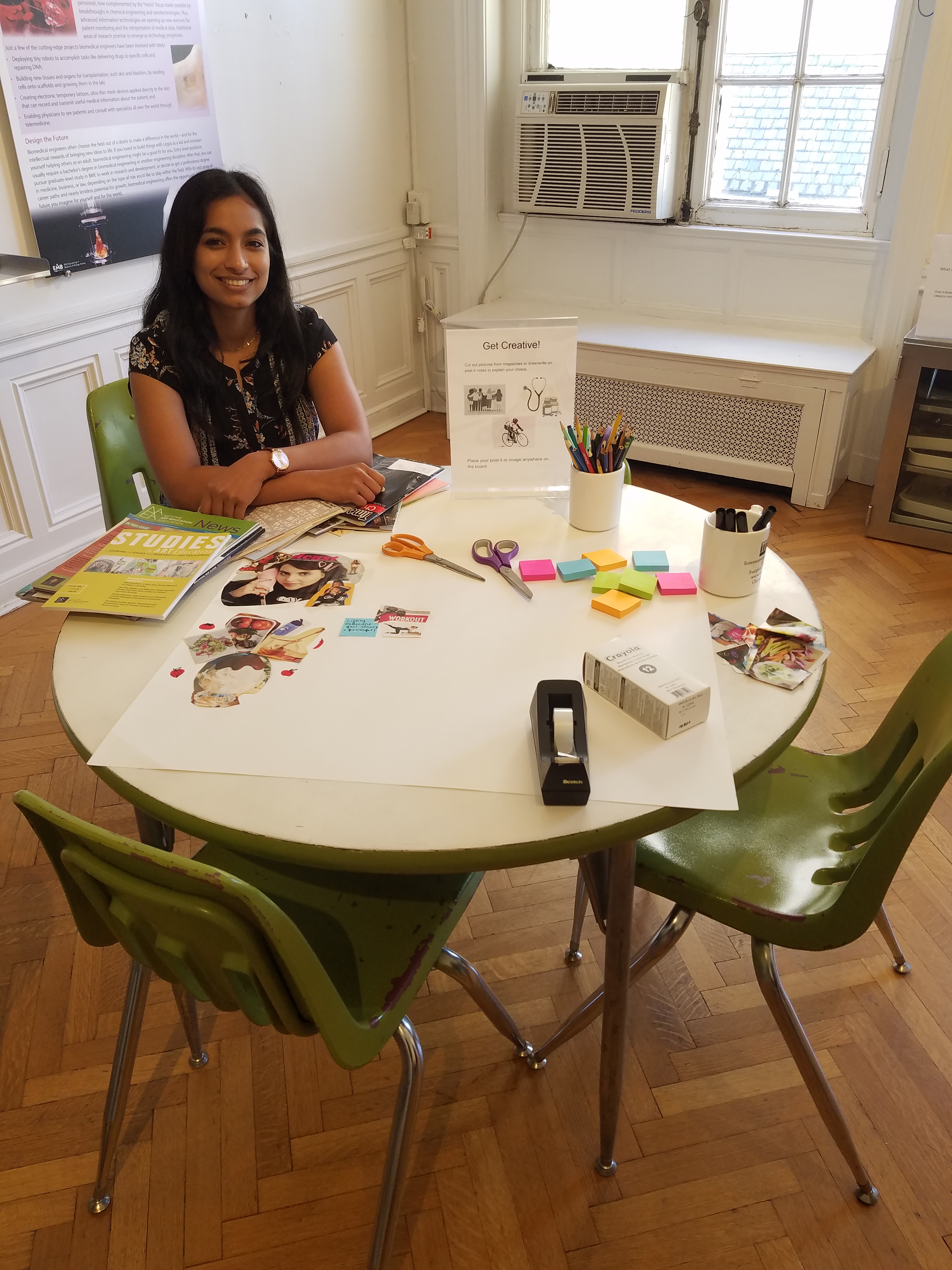 Anu sitting at a table with art supplies